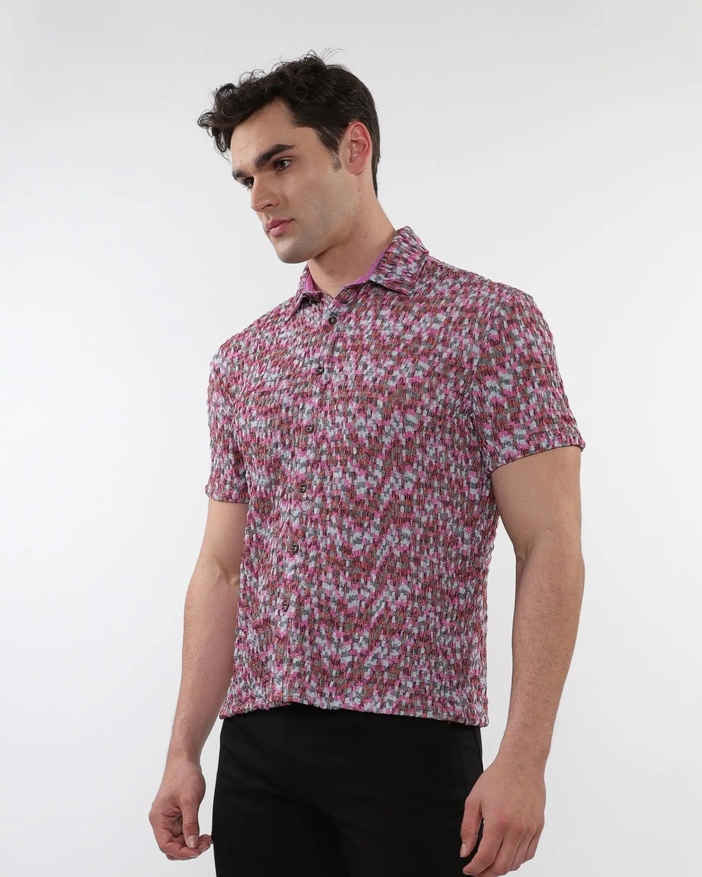 A man wearing a pink and gray crinkle knit short sleeve shirt with an abstract pattern and textured fabric