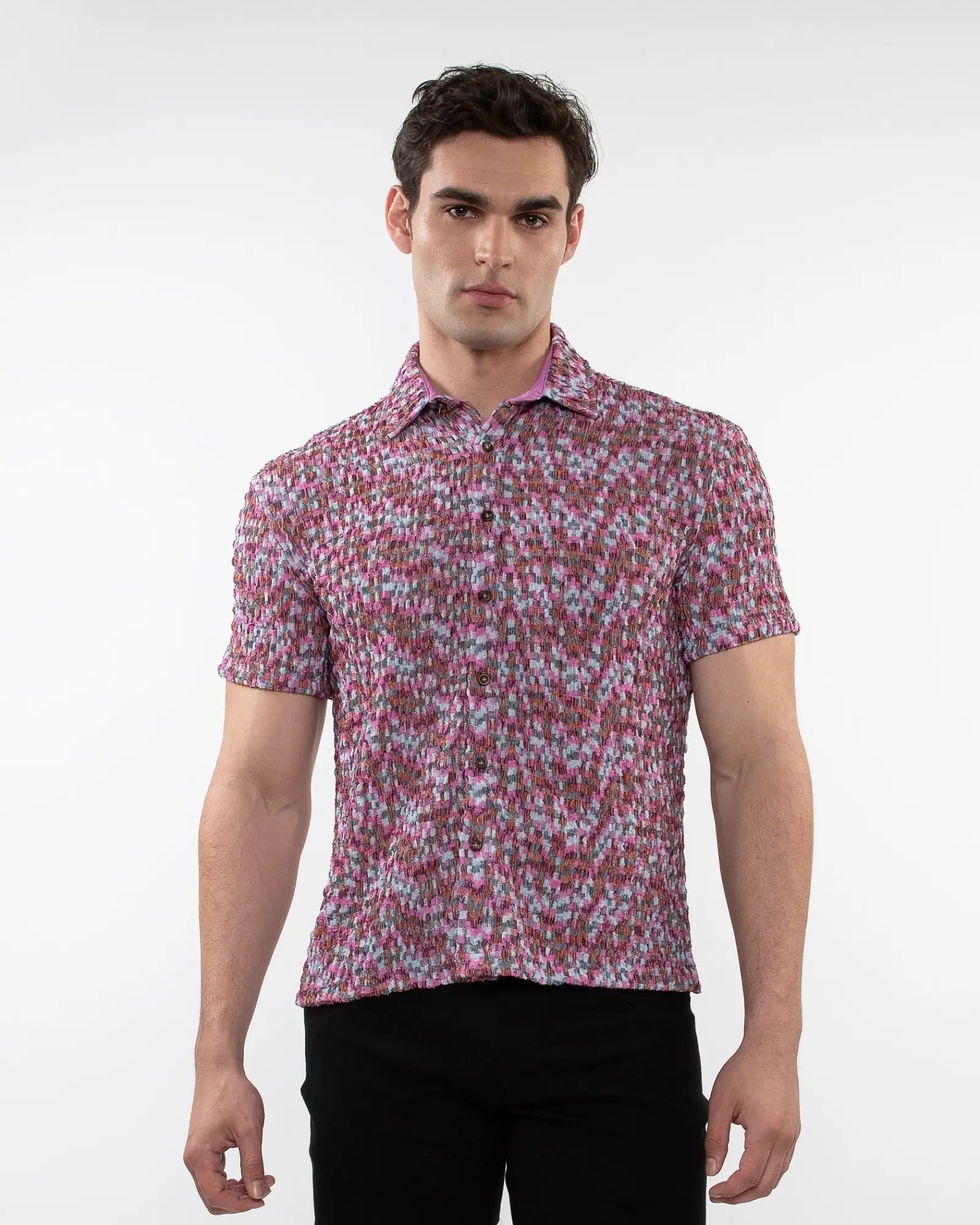 A man wearing a vibrant pink and white floral crinkle knit short sleeve shirt with button up front