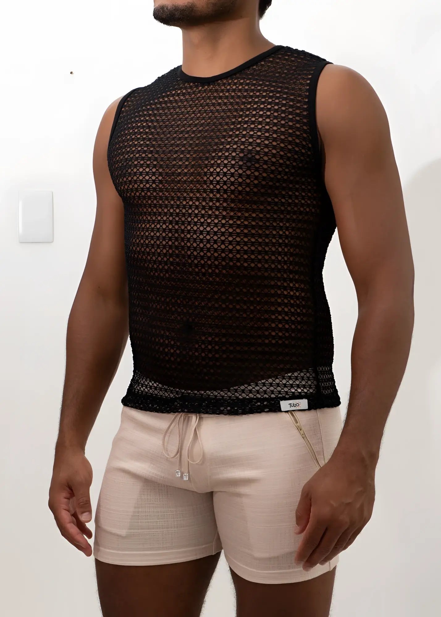 Black crochet muscle tank top with sleeveless black mesh, fitted semi-transparent design, and ribbed hem detail