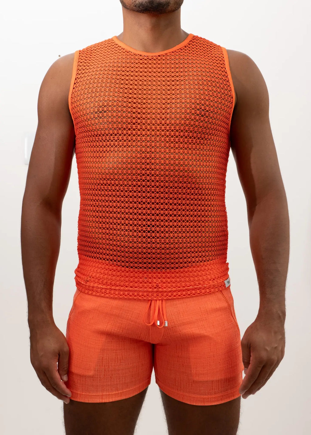 Bright orange crochet muscle tank top with fitted sleeveless design paired with matching drawstring shorts