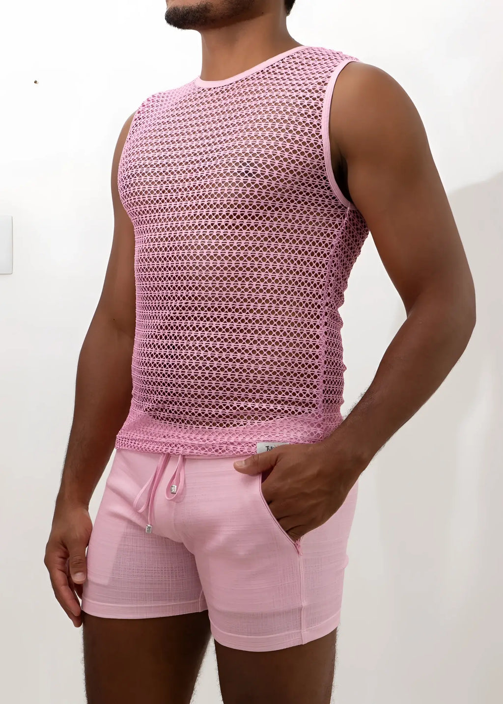 Pink crochet muscle tank top with subtle geometric mesh pattern paired with matching pink drawstring shorts