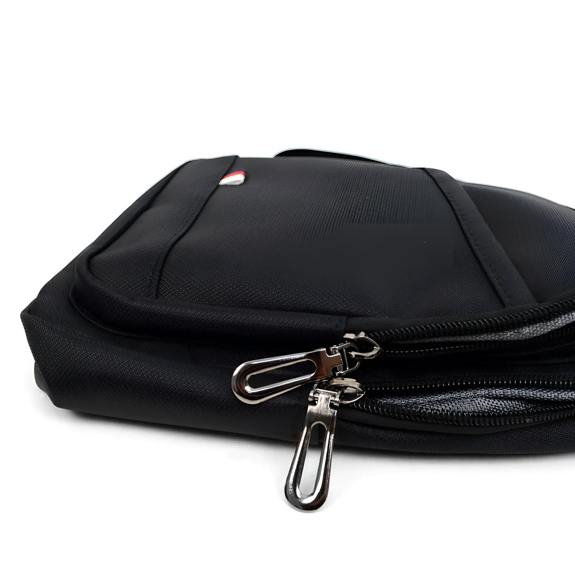 Black nylon crossbody sling bag with silver zipper pulls and a small red white and blue logo on the front