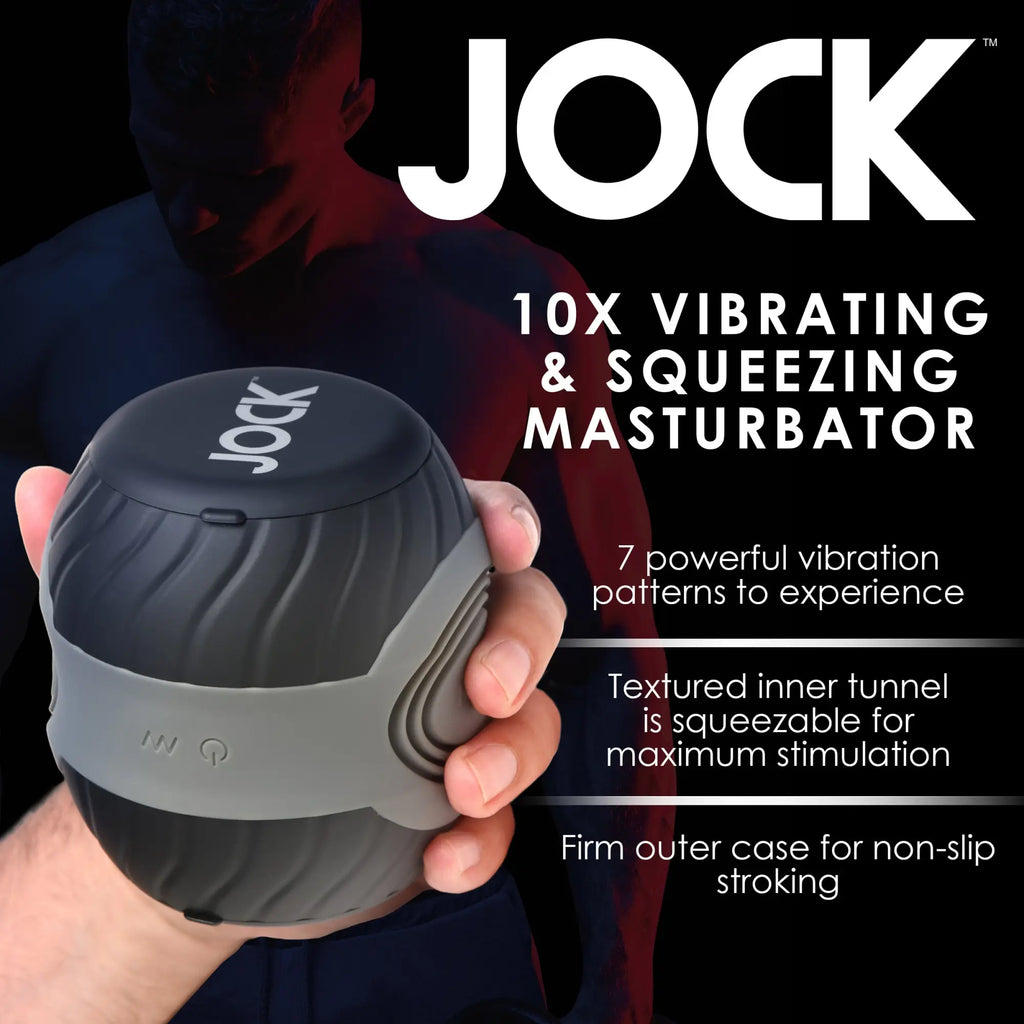 A hand holds the spherical, black-and-grey JOCK 10X Vibrating & Squeezing Masturbator against a black background.
