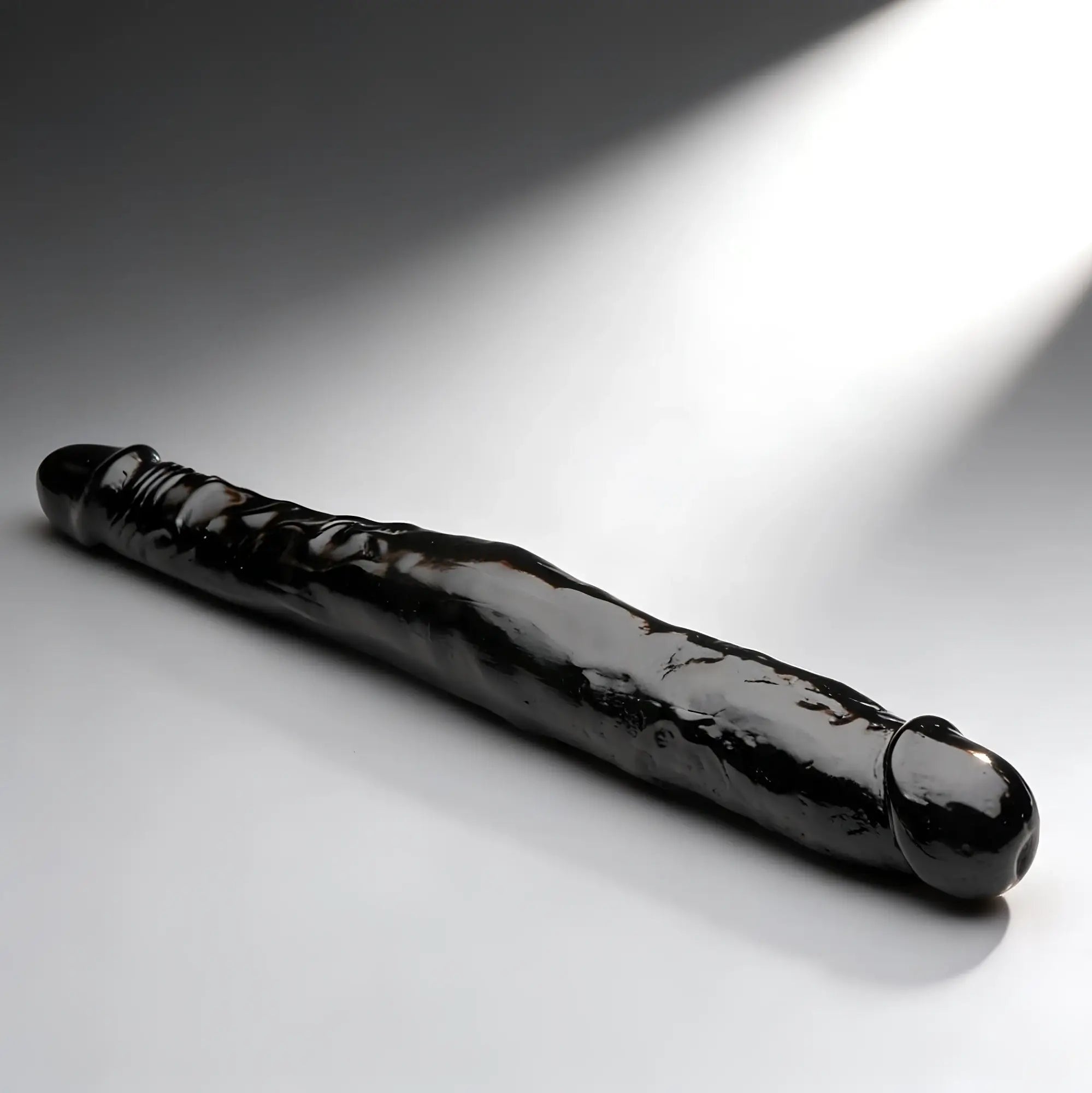 Curve Toys 13-inch tapered black double-ended dong with a realistic texture, shown against a grey spotlight background.