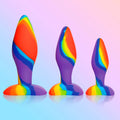 Curve Toys 3pc rainbow silicone butt plug set featuring three graduated sizes in vibrant swirled colors.