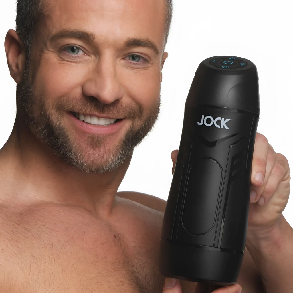 A smiling man holds a black, sleek Curve Toys 9X sucking and vibrating masturbator against a white background.