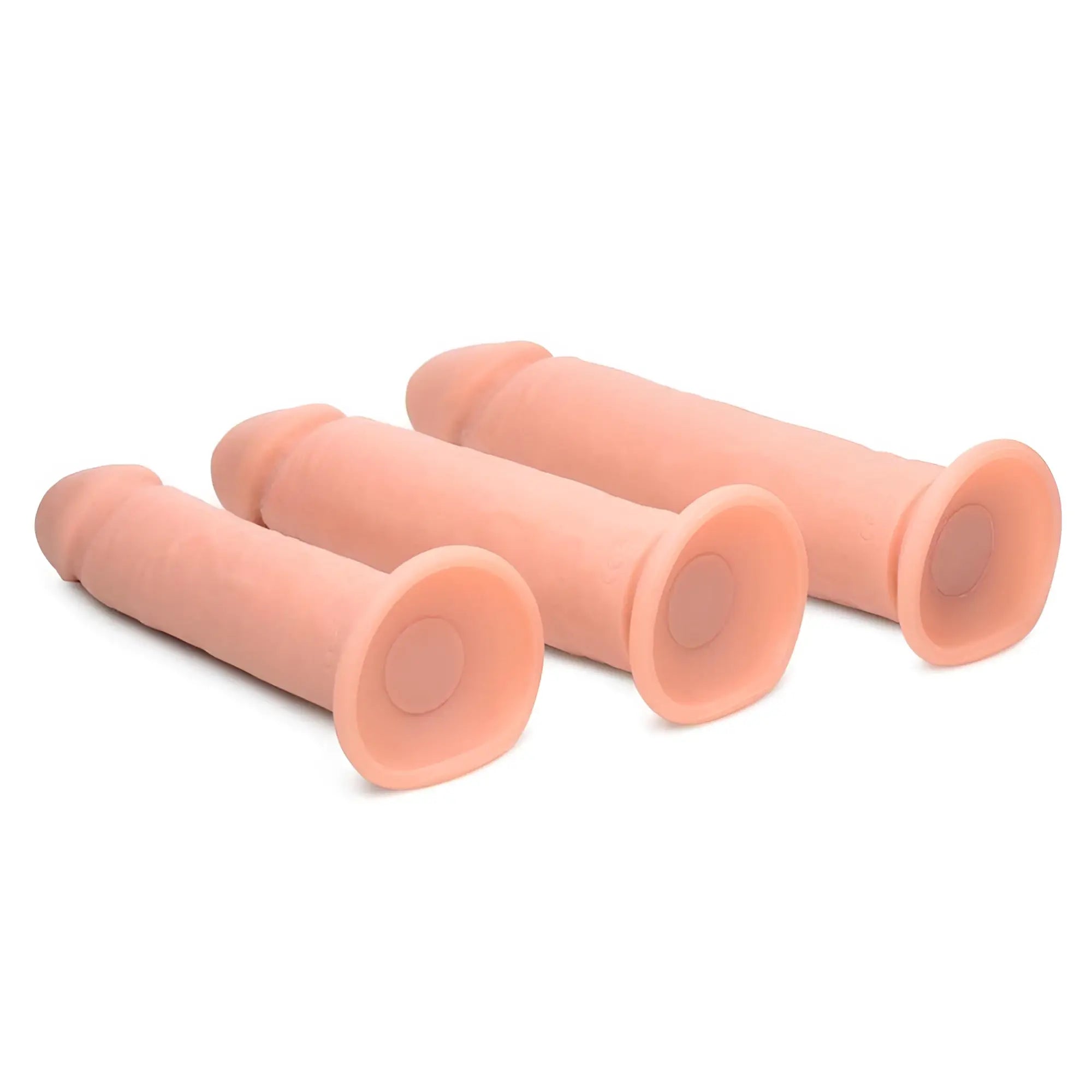 Three Curve Toys Big Shot peach-colored silicone dildos with suction cup bases arranged diagonally on a white background.