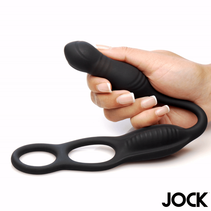 A hand holds a matte black Curve Toys vibrating anal plug with a ribbed design and connected dual cock rings.