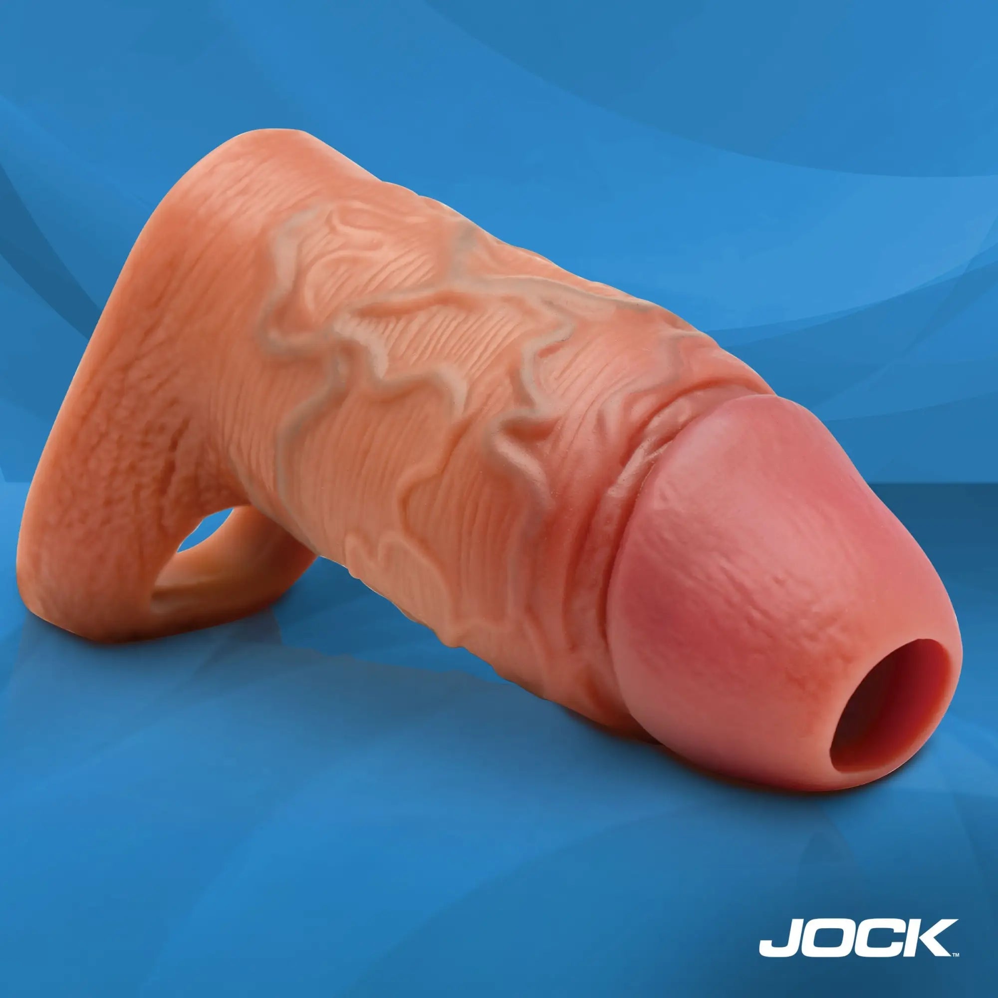 Curve Toys Enhancer: A tan, realistic textured penis sleeve with a ball strap base on a blue background.