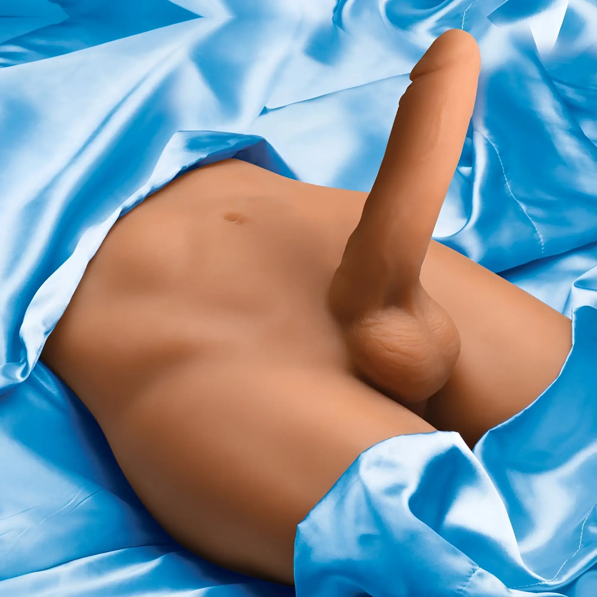 Curve Toys JOCK male masturbator with a realistic tan silicone phallus resting on shiny blue fabric.