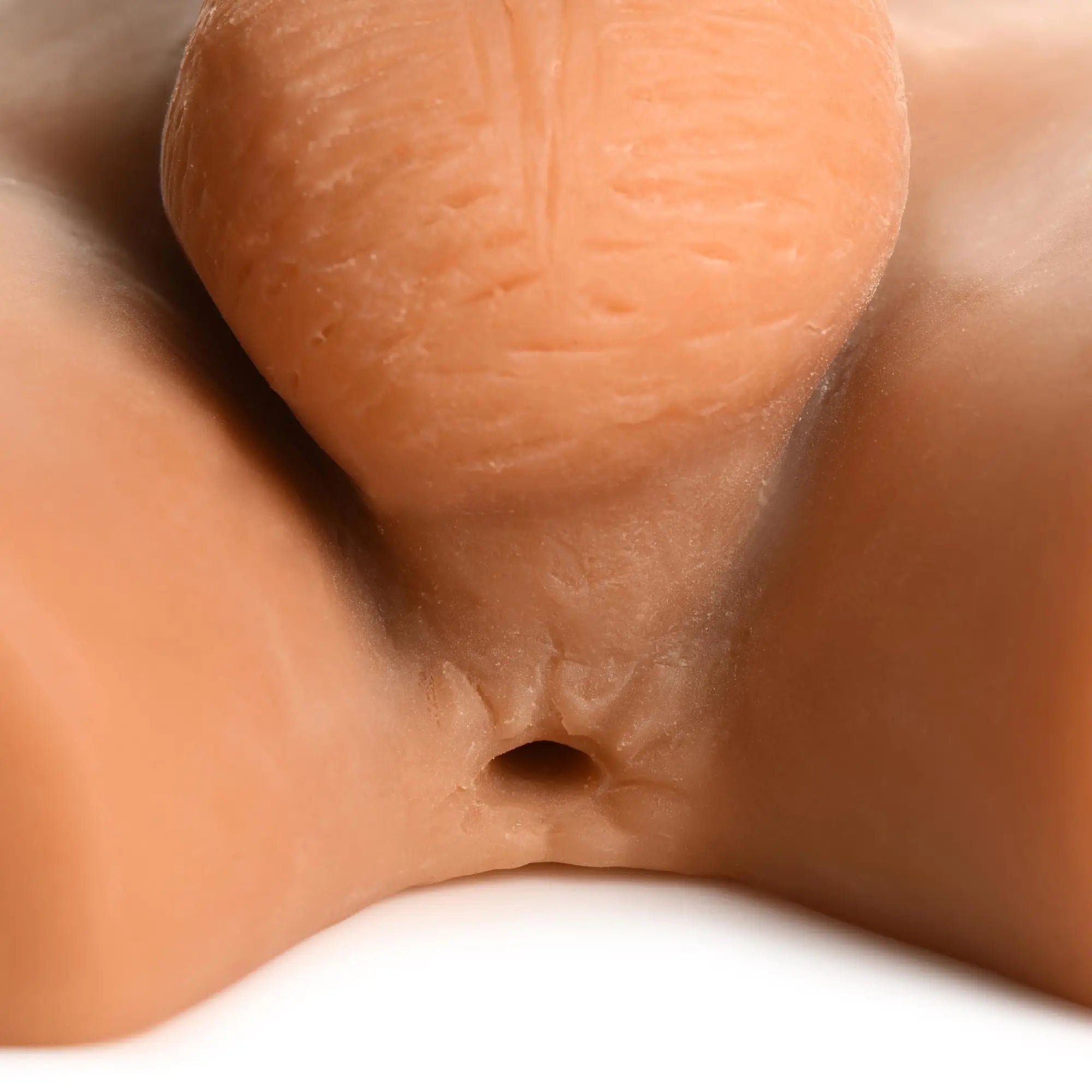Curve Toys Male Ass Masturbator with posable dildo: a realistic, skin-toned textured silicone anal opening and mound.