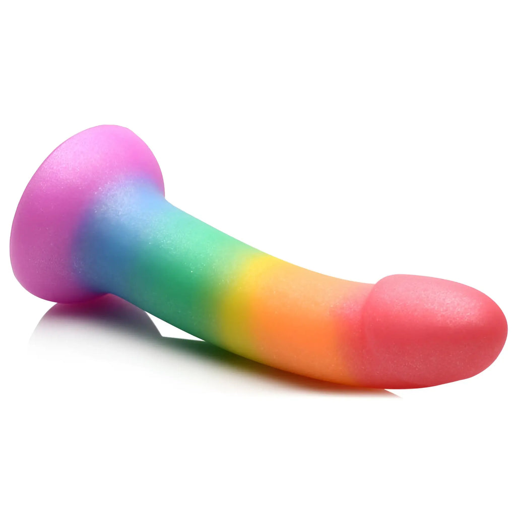 Curve Toys Phallic Rainbow silicone dildo with a curved shaft, flared base, and vibrant glittery rainbow gradient.