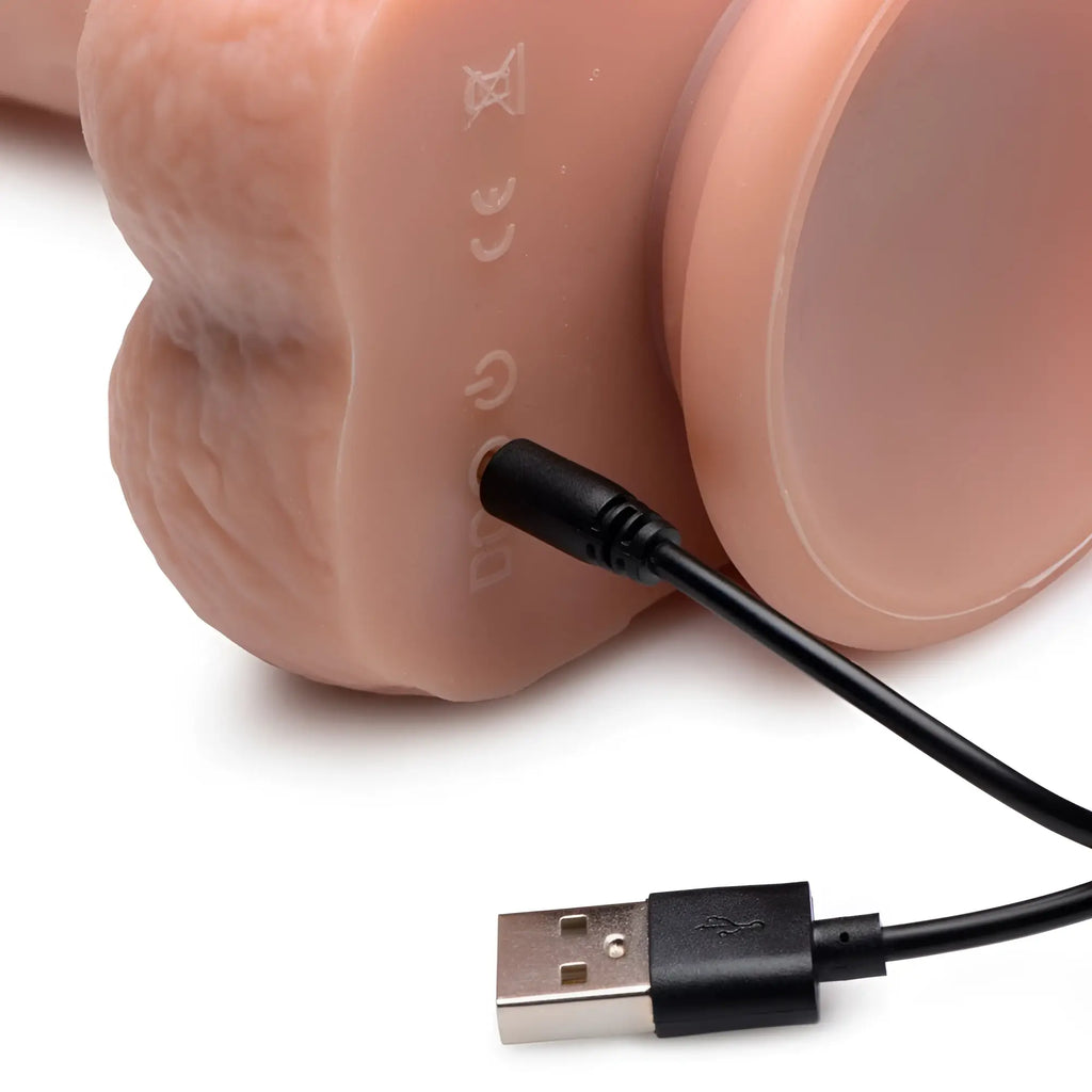 Curve Toys silicone dildo in flesh tone, shown with a black USB charging cable plugged into the base.