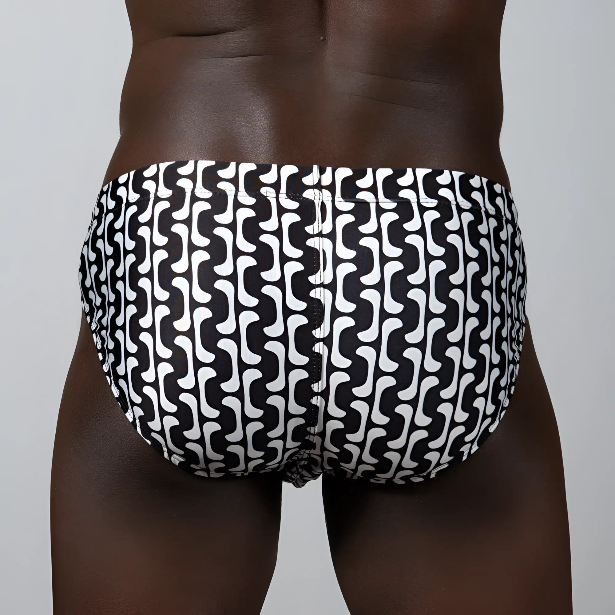 Black and white swim trunks with a bold wavy geometric pattern in the curves print brief design