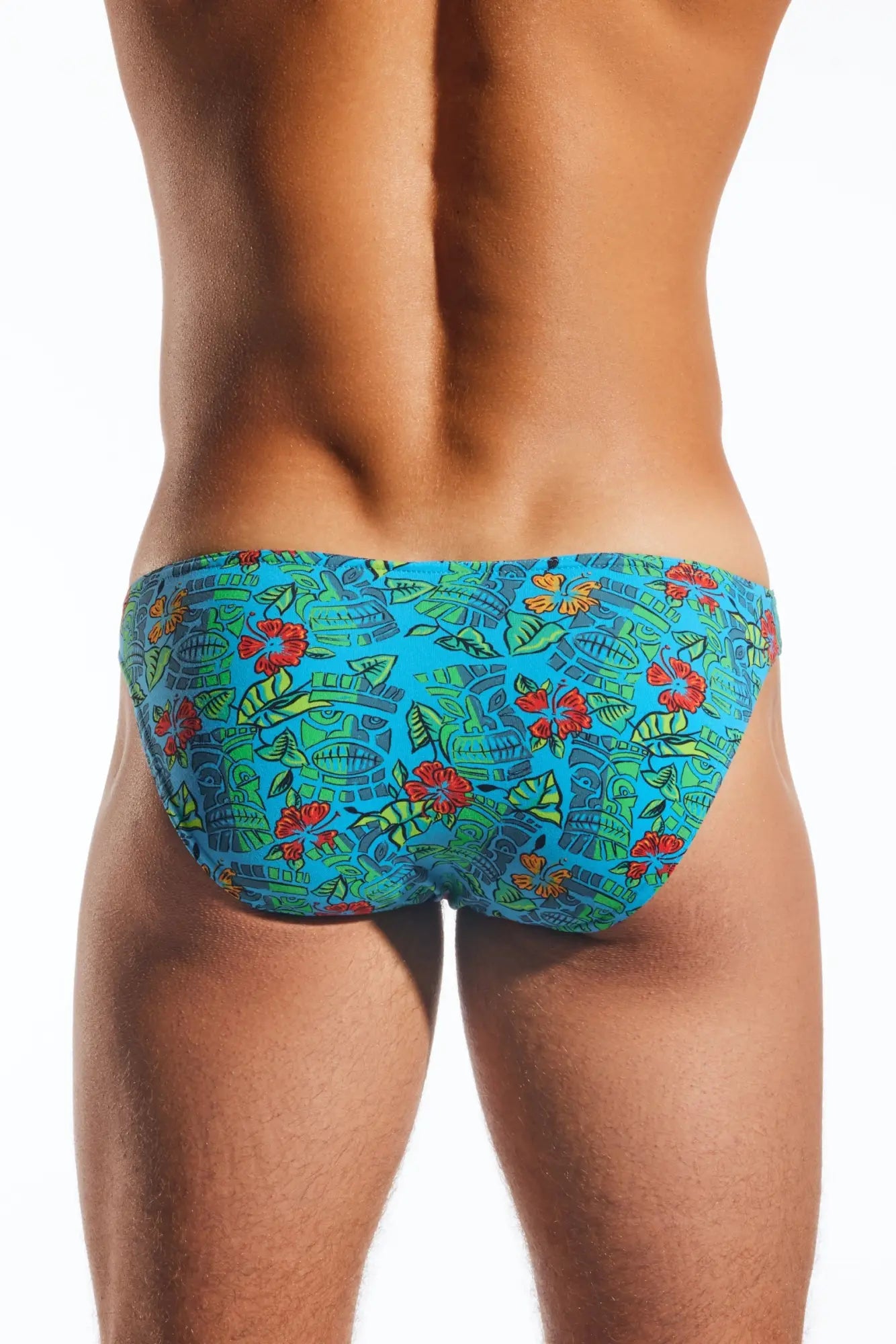 Cx01 brief vibrant turquoise swim trunks with red hibiscus flowers green leaves and stylized ancient masks pattern