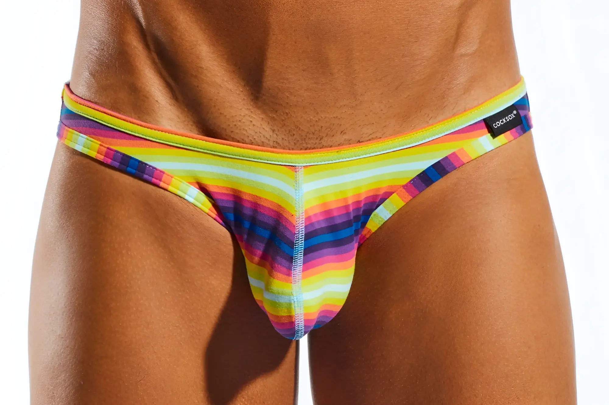 Cx01bd brief rainbow-striped men’s thong in stretchy fabric with bold neon diagonal pattern and cockade label on waistband