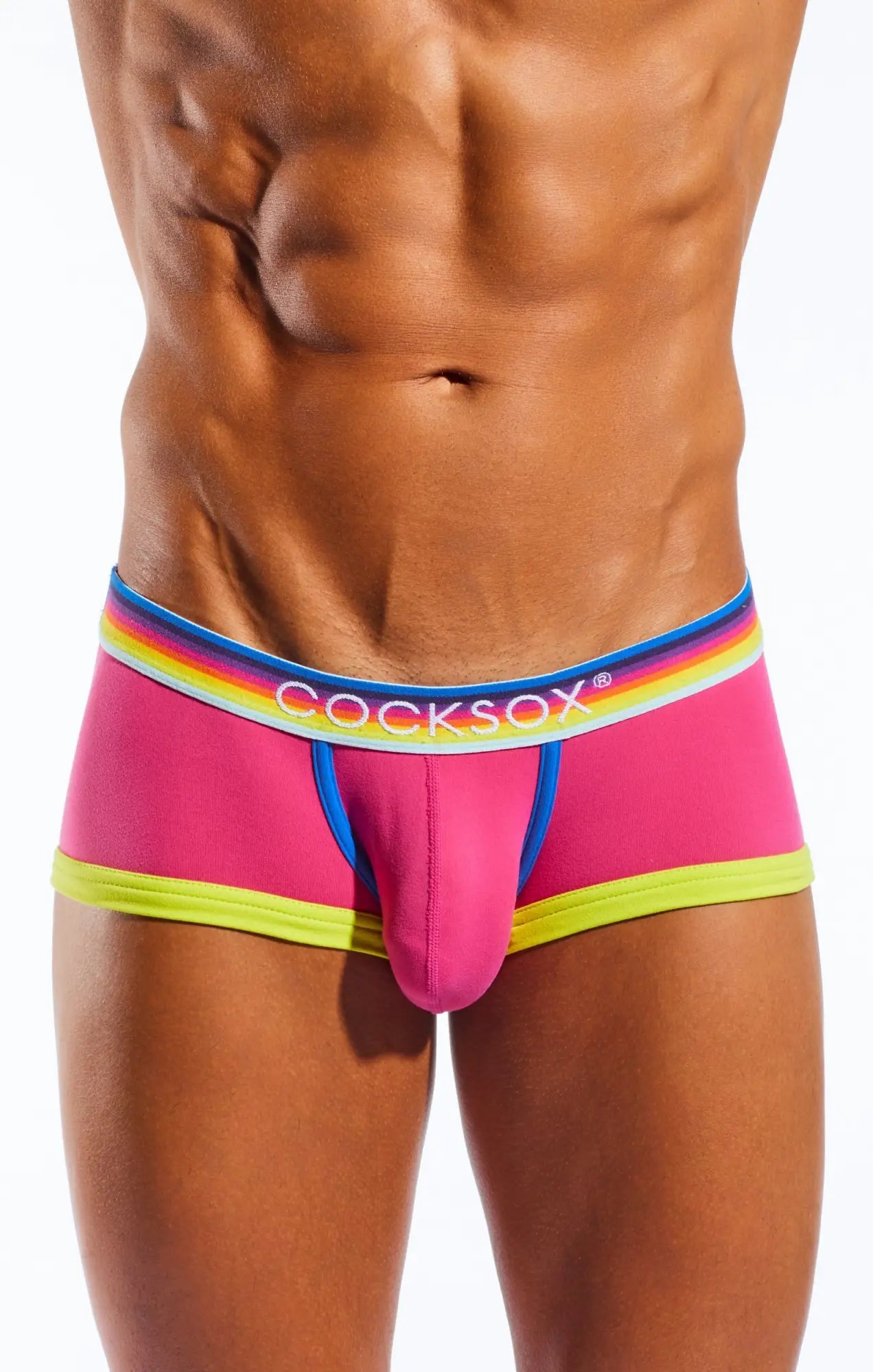 Vibrant pink cocksox cx68n trunk briefs with rainbow-striped elastic waistband and neon yellow trim for men