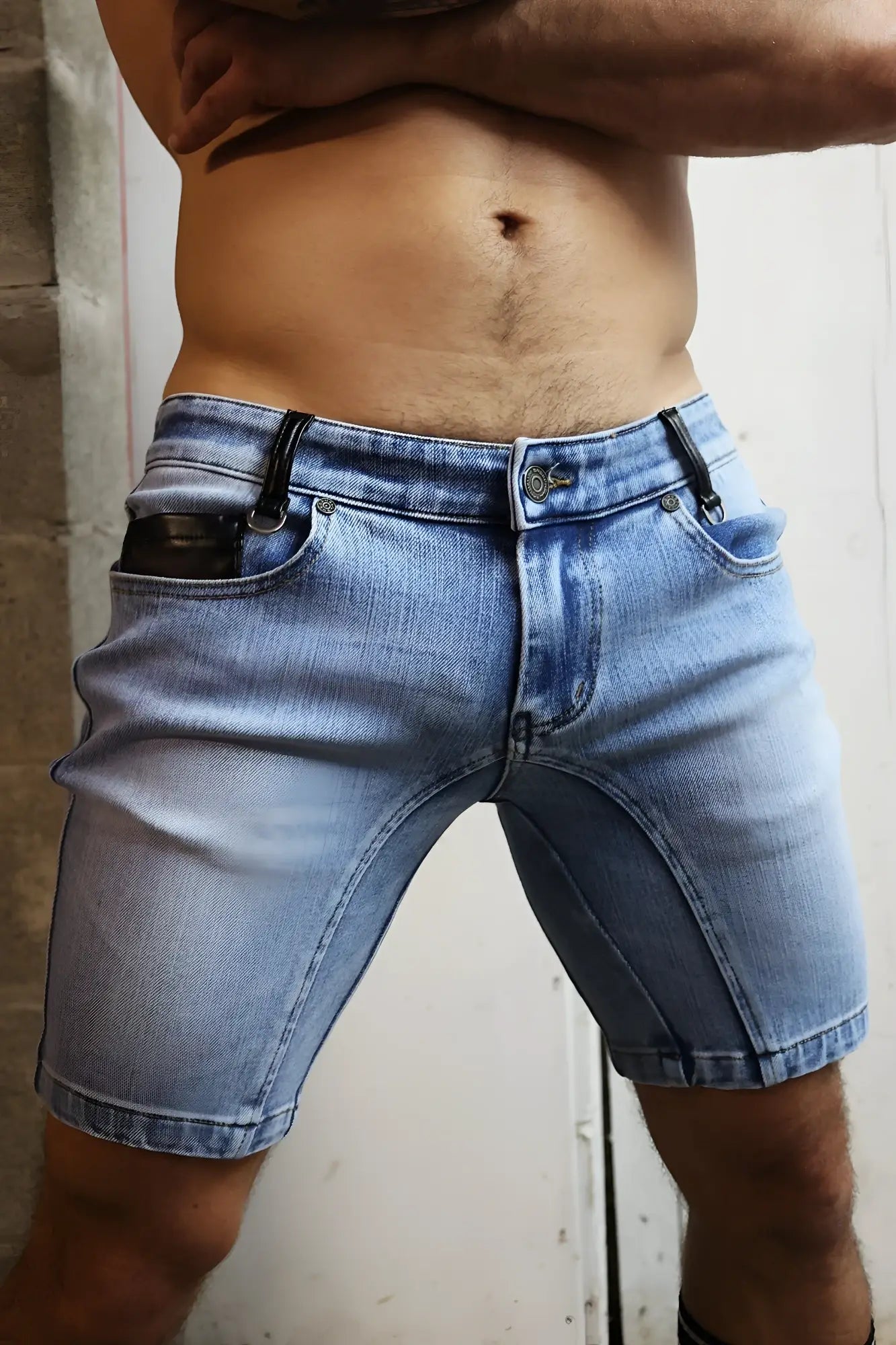 Back view of daddys favorite light-wash denim shorts with black leather accents on belt loops and back pockets