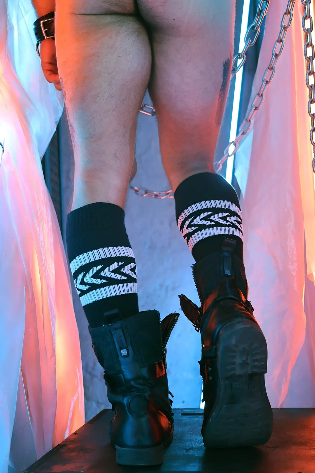 Black boots with zipper details and rugged sole paired with black daddy’s favorite socks featuring bold white geometric patterns