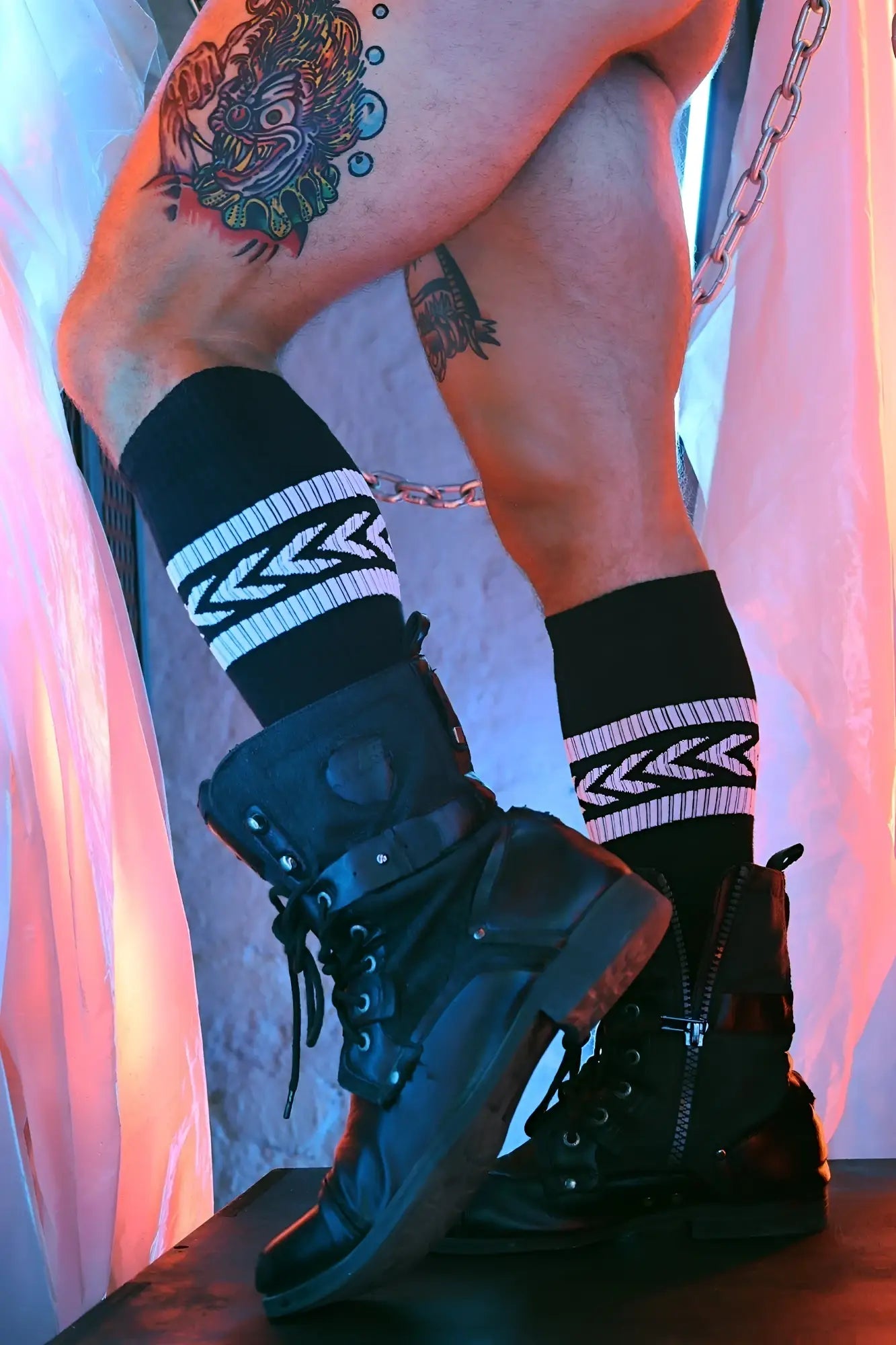 Black combat boots with laces and zippers paired with black socks featuring white zigzag patterns from daddys favorite socks