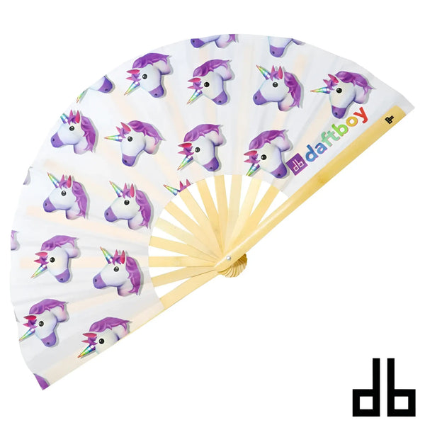A daftboy folding fan with a white fabric featuring purple-maned cartoon unicorns and rainbow horns on a light wood frame