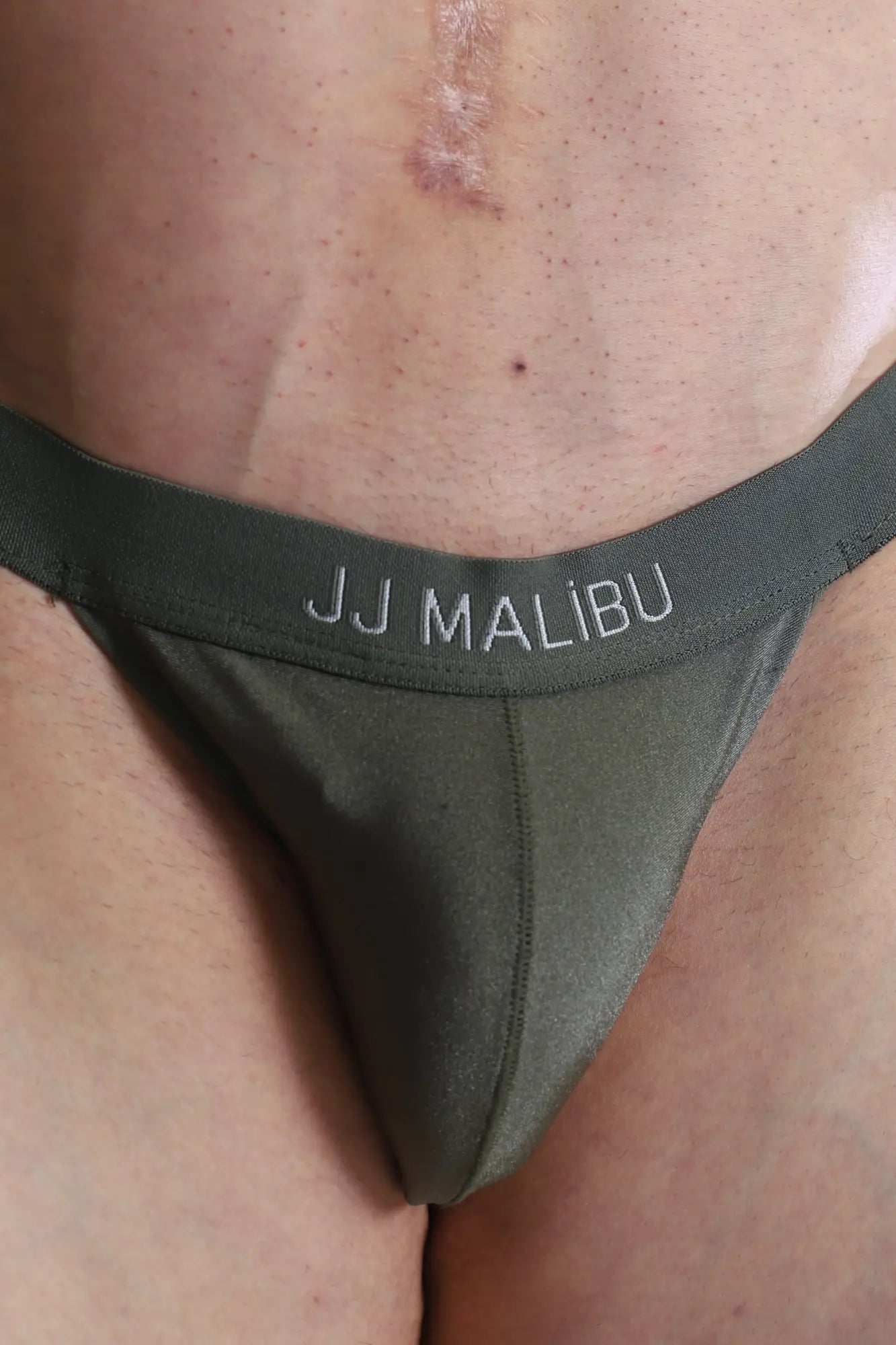 Olive green deep back V jockstrap with smooth stretchy fabric and subtle stitching shown from the back side