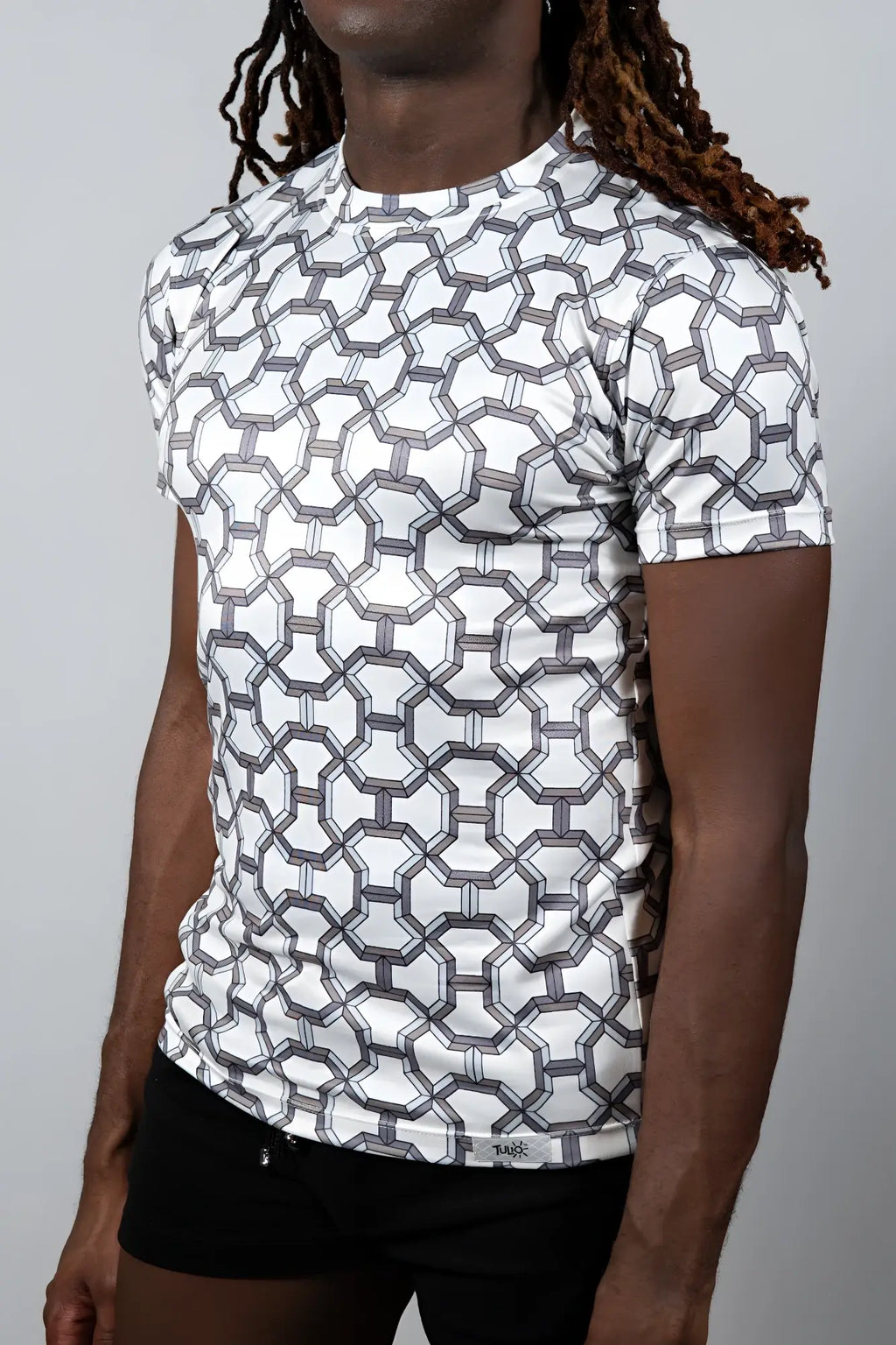 White short-sleeved rash guard with a geometric gray pattern featured in designer inspired print tee collection