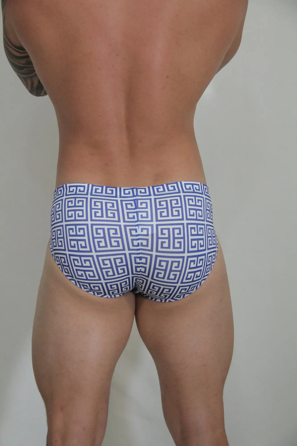 Designer print swim brief with blue and white patterned fabric featuring a repeating greek key design