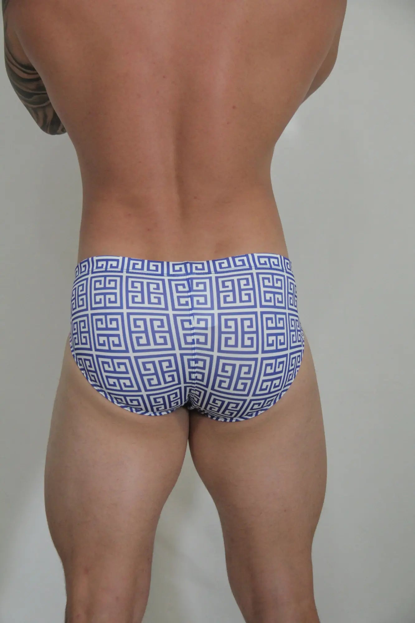 Designer print swim brief with blue and white patterned fabric featuring a repeating greek key design