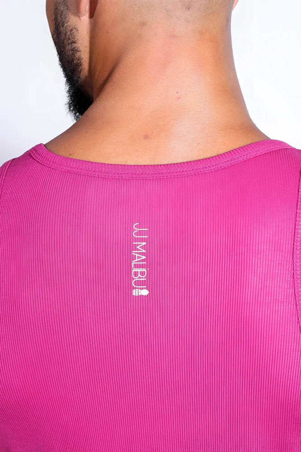 A vibrant dark pink ribbed cropped tank with vertical white jumabu logo and small emblem on the back side