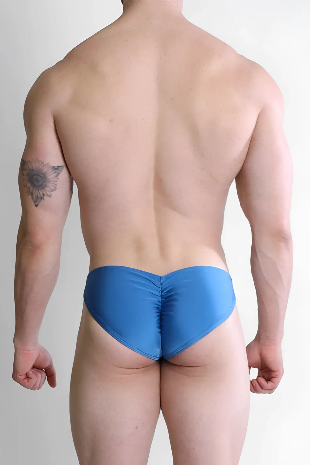 Blue satin swim trunks with ruched back design shown from the back in neon blue dynamic classic scrunch-butt brief