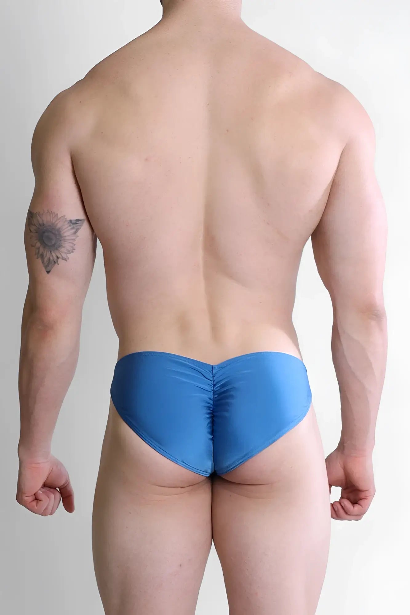 Blue satin swim trunks with ruched back design shown from the back in neon blue dynamic classic scrunch-butt brief