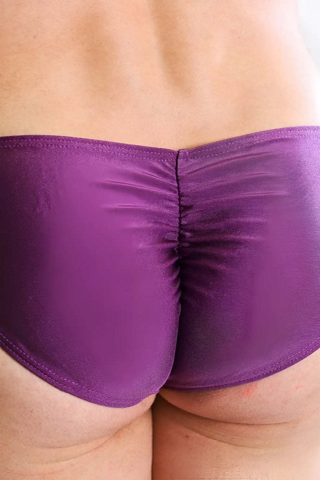 Purple shiny fabric briefs with ruched center seam showing back side of dynamic classic scrunch-butt brief