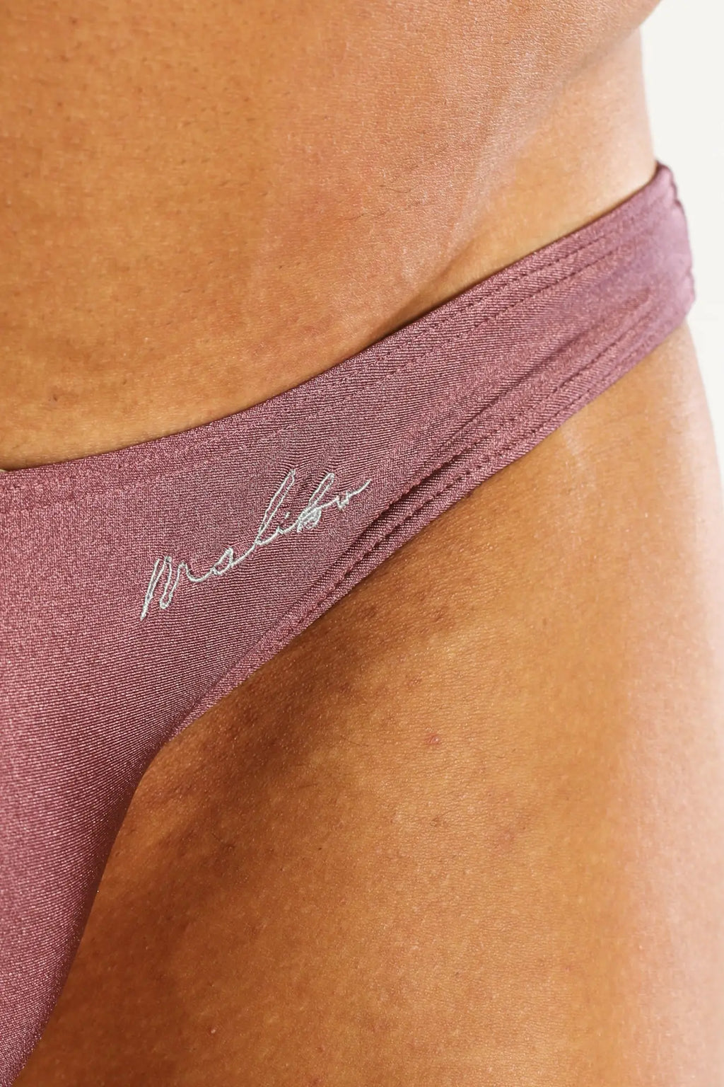 Dynamic scrunch-butt bikini briefs maroon shown from back in mauve stretchy fabric with silver malibu embroidery