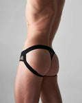 Black mesh edge net jock thong with solid black waistband and leg straps shown from the back side