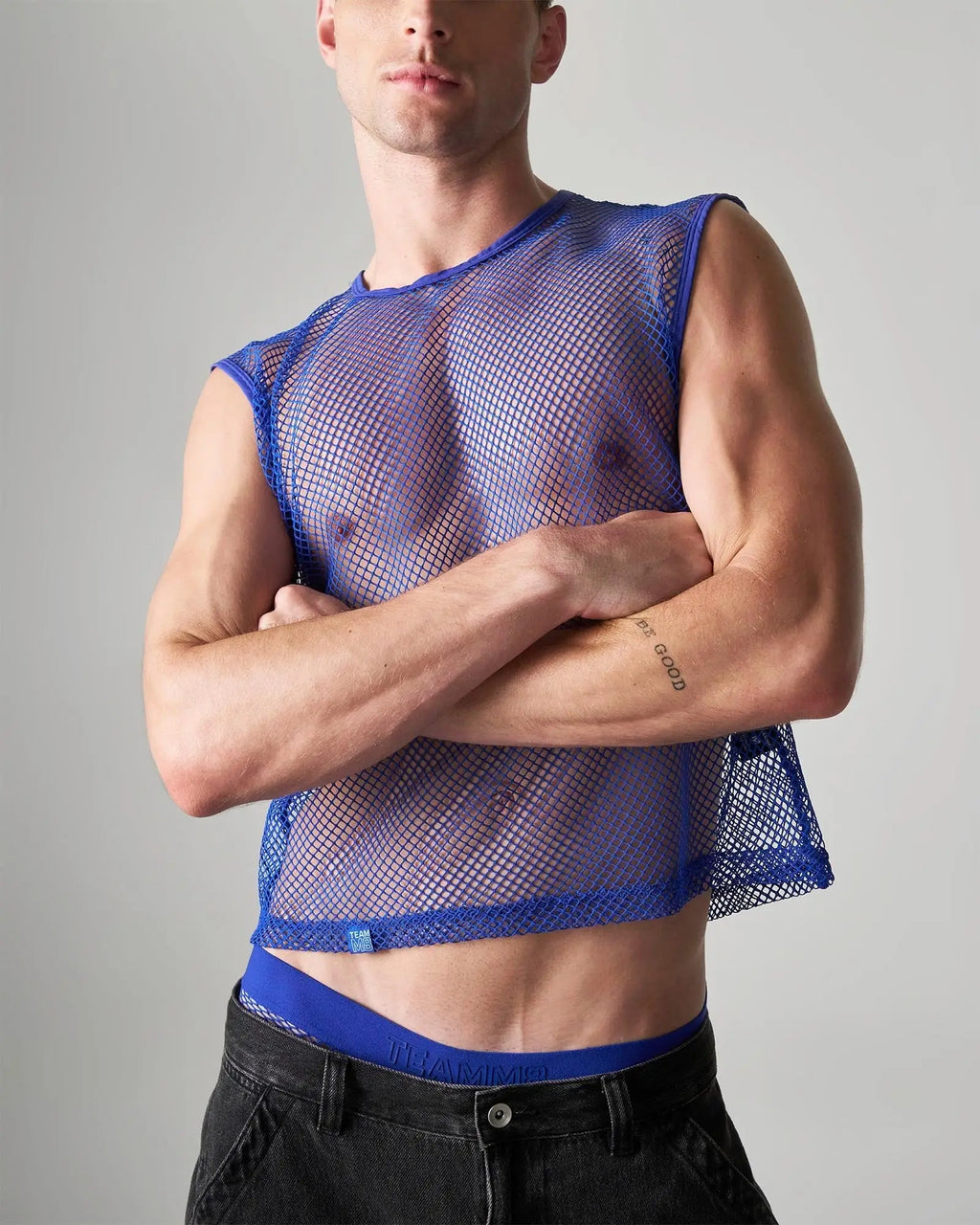 Blue mesh sleeveless muscle tank with fitted cropped design made from breathable net fabric for edgy style