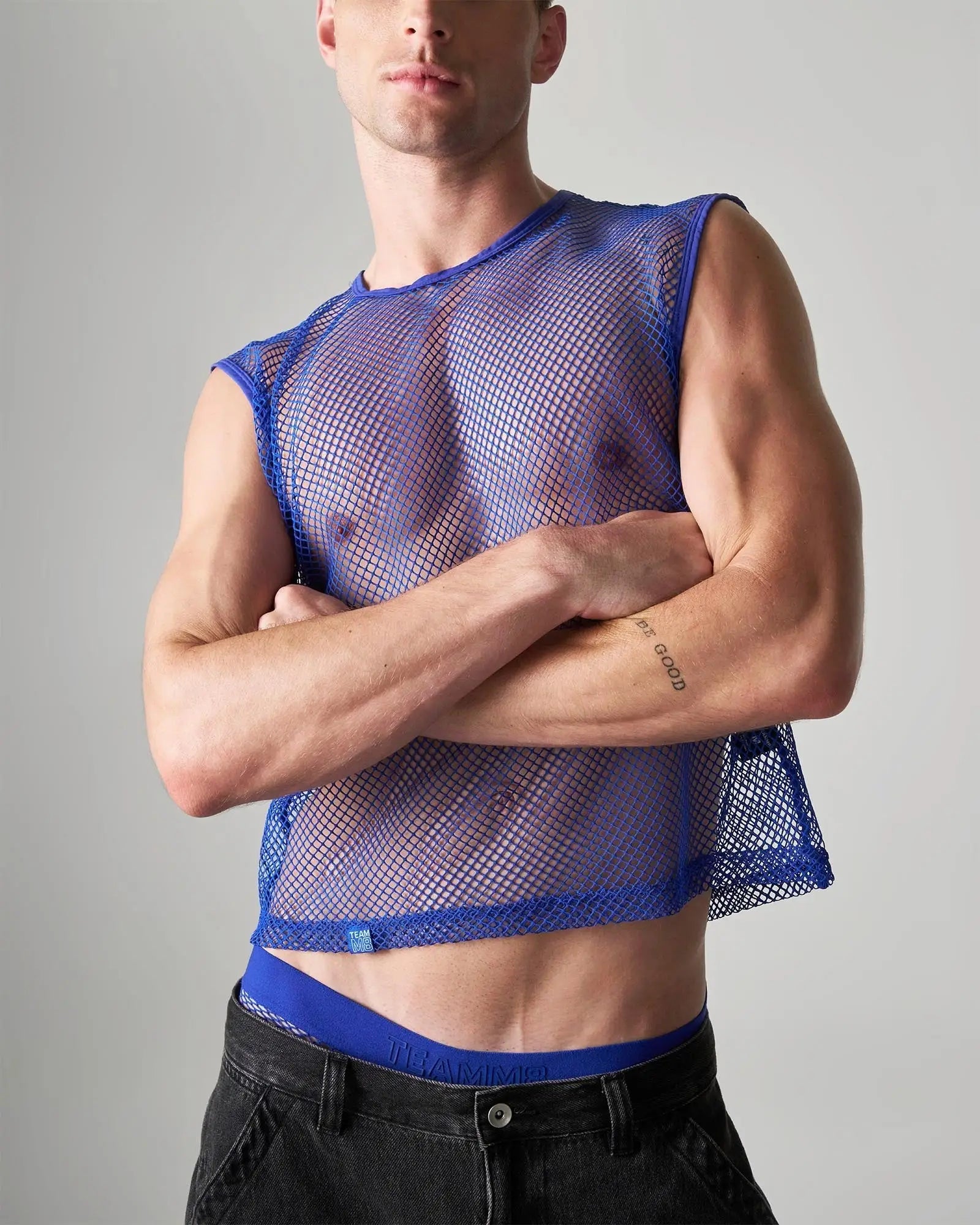 Blue mesh sleeveless muscle tank with fitted cropped design made from breathable net fabric for edgy style
