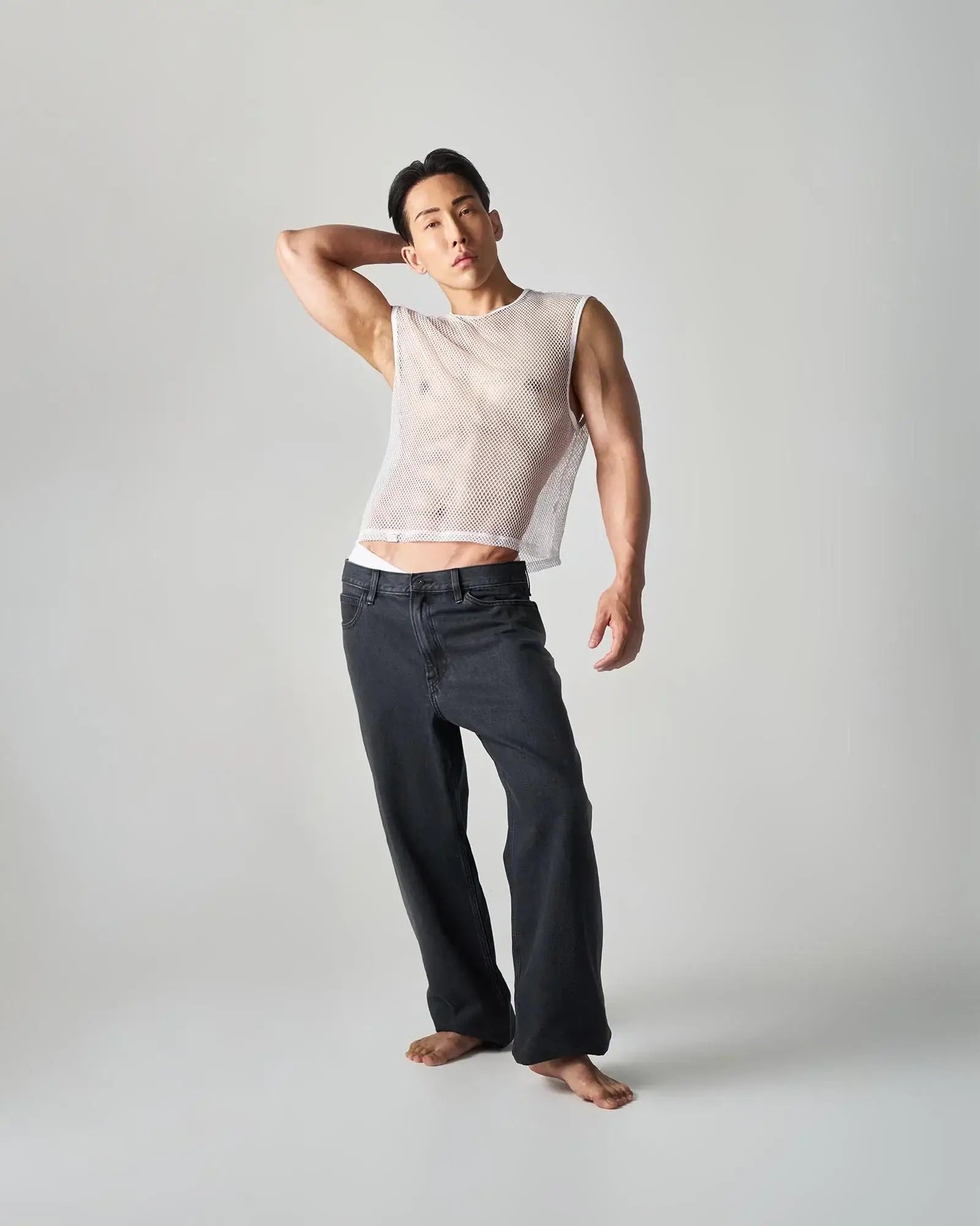 A white mesh sleeveless edge net mesh muscle tank with a fitted semi-transparent design