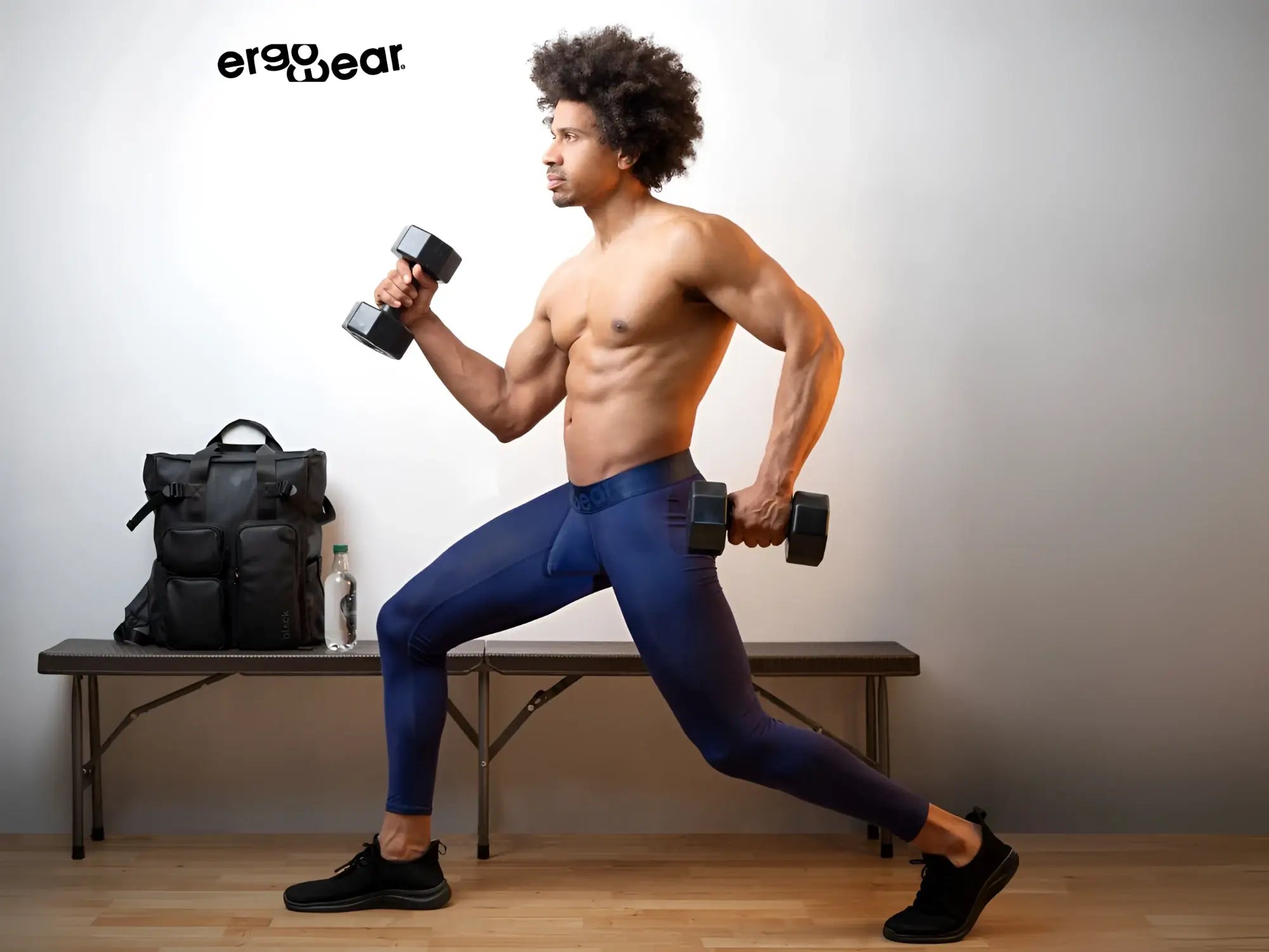Black ergonomic dumbbells with matte finish and textured grip paired with ergo wear ew1782 max bold dark blue athletic pants