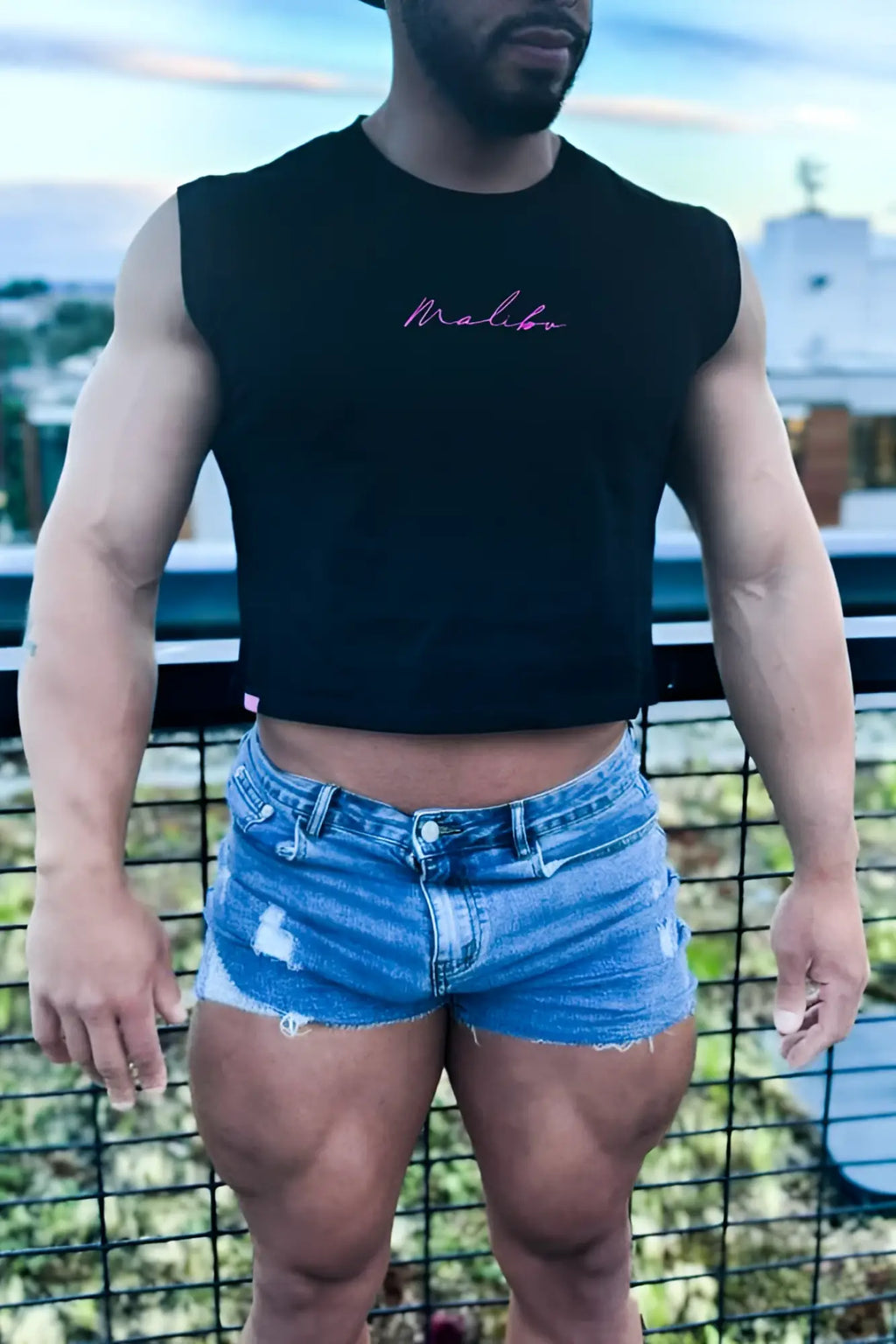 Black sleeveless muscle-fit crop tank with pink cursive malibu embroidery in jj hot pink color