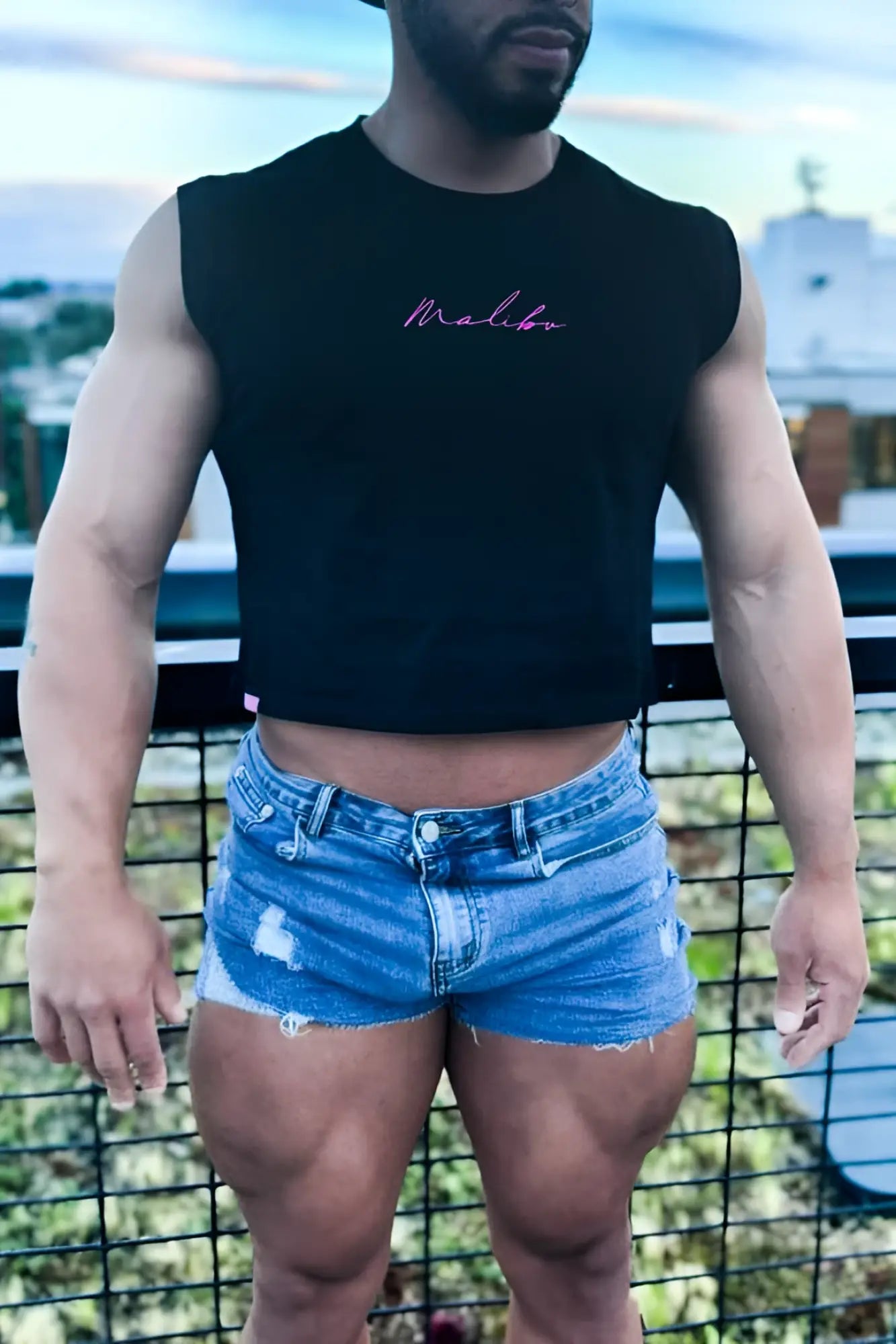 Black sleeveless muscle-fit crop tank with pink cursive malibu embroidery in jj hot pink color
