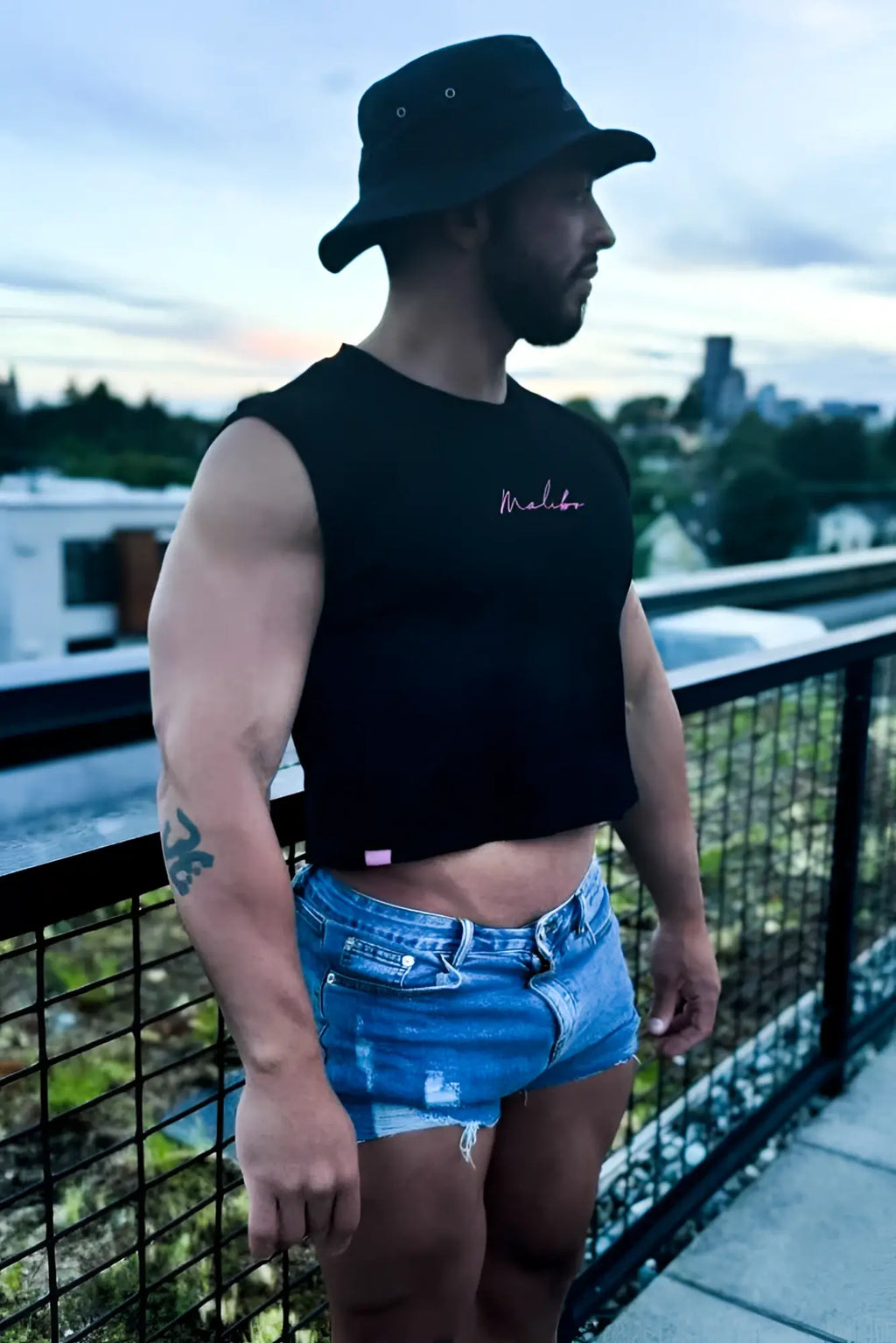 Black sleeveless muscle-fit crop tank with white embroidered malibu script and a hot pink escapism design