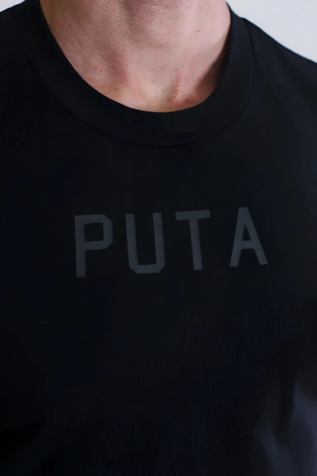 Black crew neck t-shirt with subtle gray puta logo printed across the chest from escapism muscle-fit crop tank line
