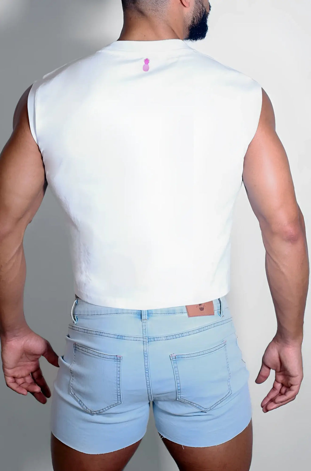 White sleeveless muscle-fit crop tank with a small purple logo at the neckline for casual wear