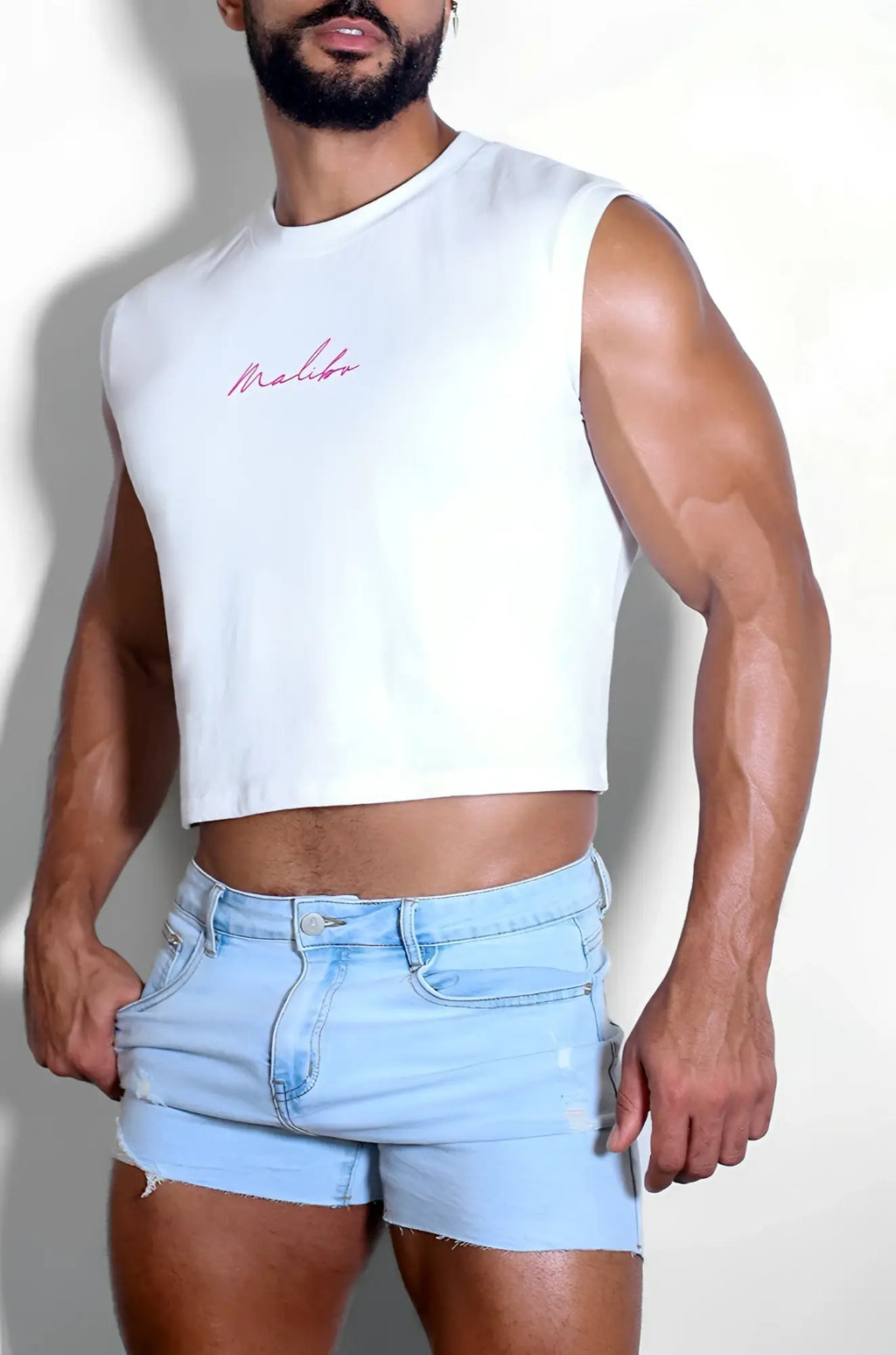 White muscle-fit sleeveless crop tank with subtle red purple cursive logo on chest perfect for casual wear