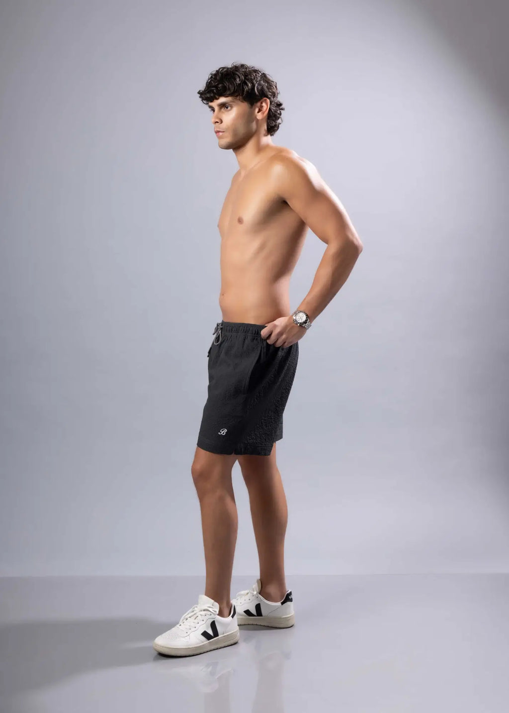 Black essential swim shorts with subtle textured pattern and small logo on lower left leg available in 3 colors