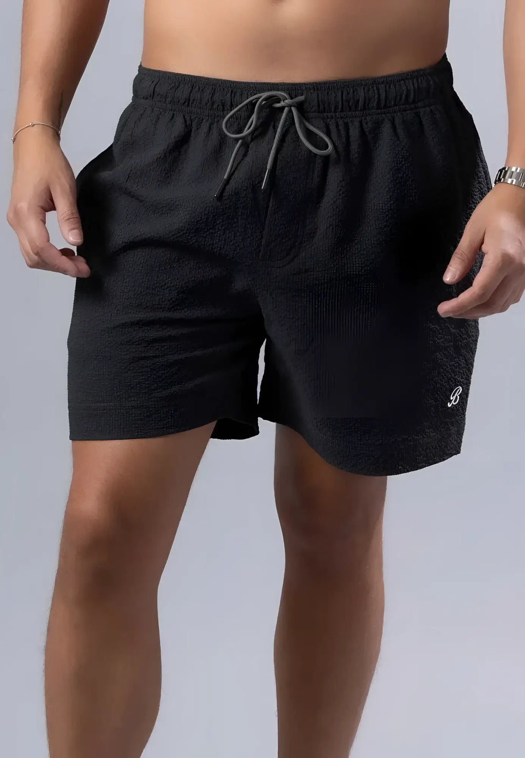 Black textured essential swim short with gray drawstring waistband and white logo on lower right leg available in 3 colors