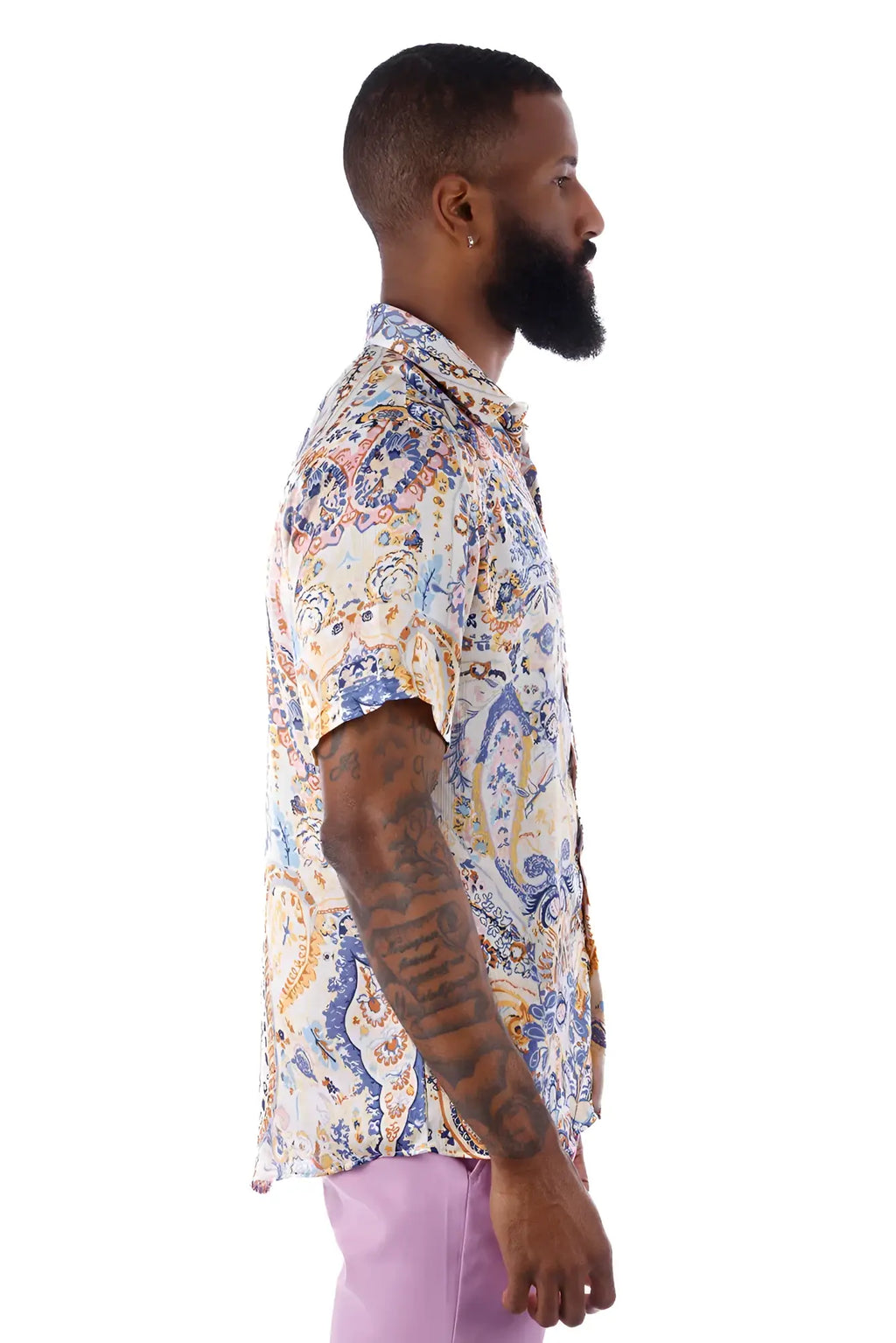 A man wearing an exclusive buzz s/s shirt with a blue orange and cream paisley pattern on a light background