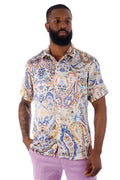 A man wearing an exclusive buzz s s shirt with a blue orange cream paisley pattern on short sleeves and light fabric