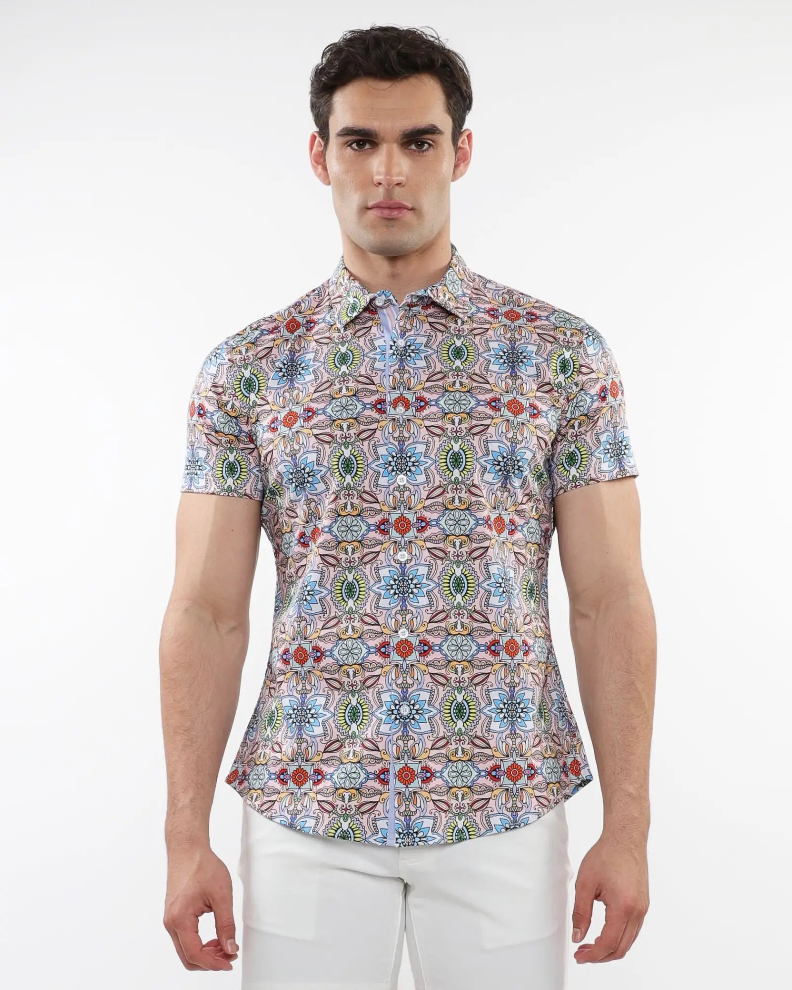 A man wearing a fauna print stretch knit short-sleeved shirt with colorful geometric pattern in blue green red and beige